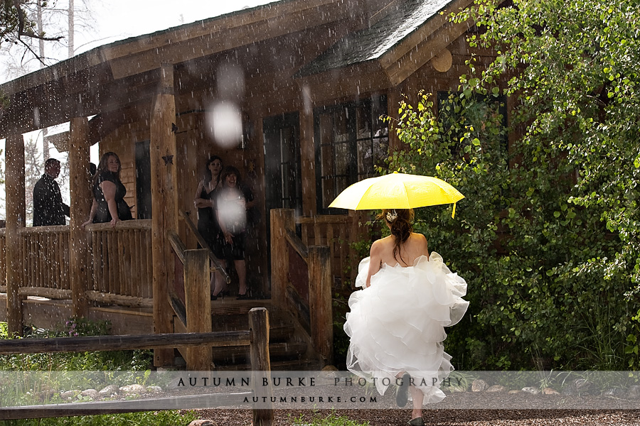 bride with yellow umbrella rain wild horse inn winter park colorado wedding