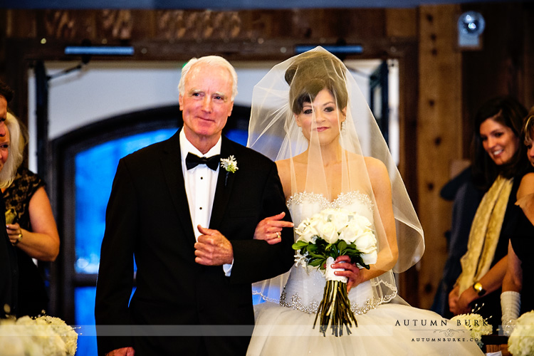 bride walks down aisle with dad vail chapel wedding ceremony winter colorado