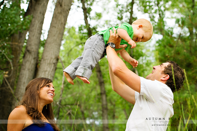 mom and dad and flying baby family portrait outdoors colorado